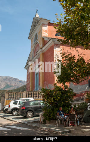 Korsika: Sitzplätze im Freien in der Nähe der Rosa gemalte Kirche des hl. Julie (xvi Jahrhundert) in Nonza, einem berühmten Dorf an der Westküste des Cap Corse Stockfoto