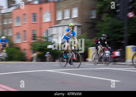 Mann, der Handy hält, während er Fahrrad fährt, London Prudential Cycle Race, London UK, 30. Juli 2017. Stockfoto