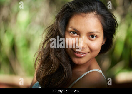 Lächelnd brünette Frau close-up Portrait auf natürliche verschwommenen Hintergrund Stockfoto