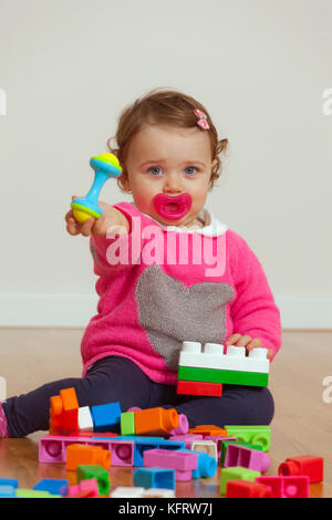 Kleinkind baby girl spielt mit weichem Gummi Bausteine. Stockfoto