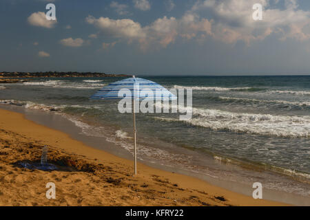 Einsamer Sonnenschirm am Strand, Avola, Sizilien, Italien, Oktober 2017 Stockfoto