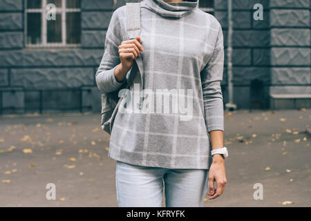 Zugeschnittenes Bild einer schlanken Mädchen in einem karierten pullover in der Stadt Stockfoto