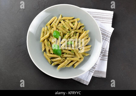 Hausgemachte Pasta mit Pesto in eine graue Platte auf einem dunklen Stein Hintergrund, Ansicht von oben, kopieren. frische Sommer essen Stockfoto