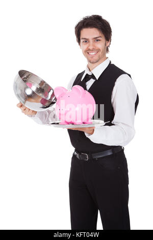 Porträt von einem Butler mit Sparschwein auf einem Tablett. Isoliert auf weiss Stockfoto