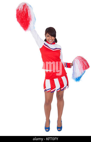 Lächelnden schönen Cheerleader mit Pompons. Isoliert auf weiss Stockfoto