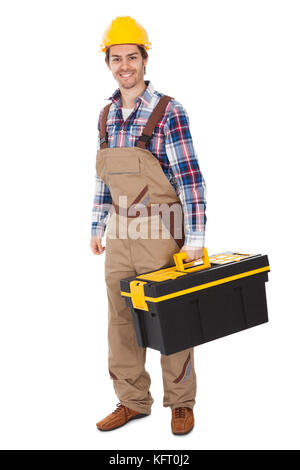 Zuversichtlich Handwerker tragen Schutzhelm und Holding-Toolbox. Isoliert auf weiss Stockfoto