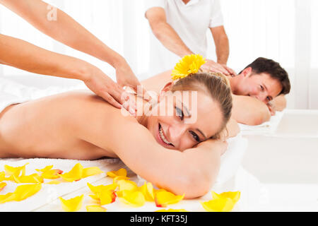 Attraktive Paar liegen nebeneinander in einem Spa den Luxus einer tiefe Gewebe zurück Massage zu genießen Stockfoto