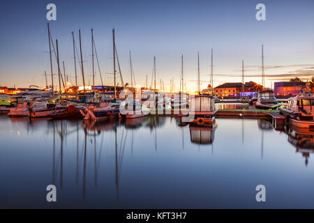 Dramatischer Sonnenaufgang über dem Hafen von Tallinn. moderne Marina für Freizeit Schiffe im Herzen der Stadt. Stockfoto