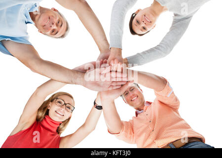 Teamwork und Zusammenarbeit Konzeptbild von vier lässigen mittleren Alters Freunden isoliert auf weiss Stockfoto