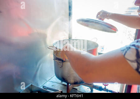 Person kochen ein momo Lebensmittel über eine metallische Fach in der Küche, die Art der Südasiatischen Knödel in Tibet, Nepal, Bhutan und Sikkim in Nepal Stockfoto