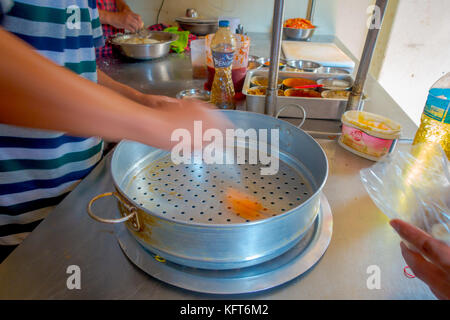 Pokhara, Nepal Oktober 10, 2017: Person kochen ein momo Lebensmittel über eine metallische Fach in der Küche, die Art der Südasiatischen Knödel in Tibet, Nepal, Bhutan und Sikkim in Nepal Stockfoto