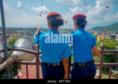 KATHMANDU, NEPAL - 04. SEPTEMBER 2017: Porträt zweier Wärterinnen, die der Kamera einen Rücken geben, von der nepalesischen Armee, die sich vor dem Eingang des Bindabasini-Tempels in einem Naturhintergrund für die Kamera posiert Stockfoto