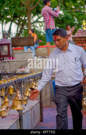 Pokhara, Nepal Oktober 10, 2017: Unbekannter Geschäftsmann berühren die Glocken unterschiedlicher Größe hängen in Taal barahi-Tempel, Pokhara, Nepal Stockfoto