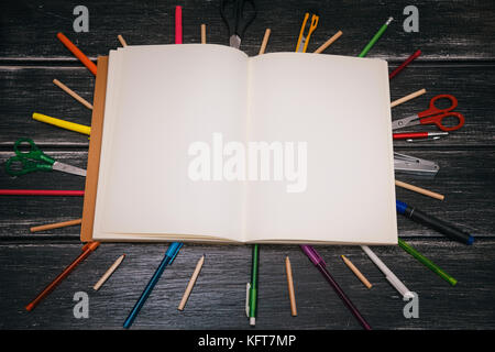 Schreibwaren und Notebook - Bunte Bleistifte und Material Ausrüstung auf Holz- Hintergrund Stockfoto