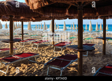 Morgen Paradise White Sandy Beach Malediven des Salento mit Sonnenschirmen und Sonnenliegen (Lido Marini, Salento, Apulien, Süditalien). Das schönste Meer sa Stockfoto