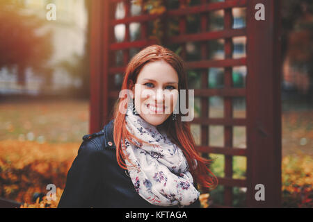 Junge kaukasier rothaarige Frau Porträt im Park im Herbst lächelnd Stockfoto