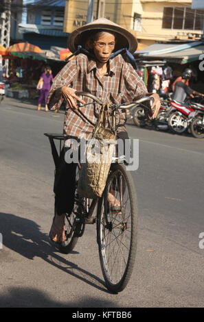 Ältere Radfahrerin in den Straßen von Hanoi, Vietnam Stockfoto