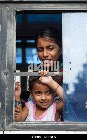 Frau und Kind blicken vom Busfenster in Cooch Behar, Westbengalen, Indien Stockfoto