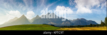 Ländlichen Gebieten in der Nähe der Tatra im Sommer Zeit. schöne Panorama der landwirtschaftlichen Fläche. Wunderschöne Bergrücken mit hohen felsigen Gipfeln Stockfoto