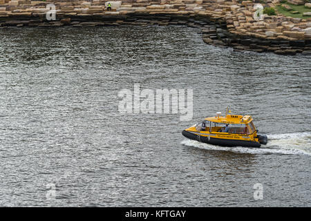 Sydney, Australien - 21. März 2017: Nahaufnahme von kleinen gelben Wassertaxi unterwegs an Millers Point. Fluggäste und felsigen Ufer. Stockfoto