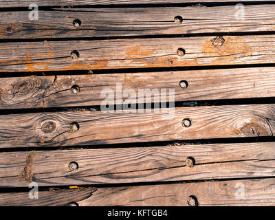 Alte Holzbretter, grobkörniges Holzmuster mit alten sechseckigen Nägeln und Farbspritzer. Stockfoto