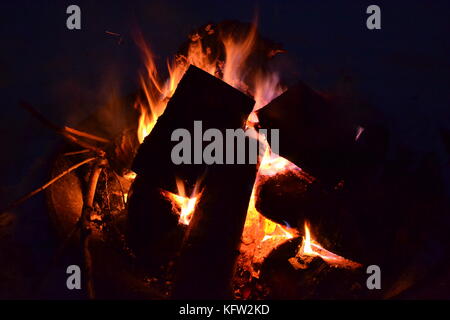 Nachts am Lagerfeuer in dunklen Hintergrund Stockfoto