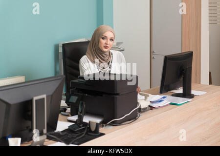 Glückliche junge muslimische Business Frau Arbeit in modernen Büro auf dem Computer Stockfoto