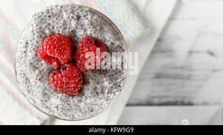 Joghurt mit Chia Samen und Früchte, Bananen und Himbeeren. gesundes Frühstück oder Snack am Morgen Konzept Stockfoto