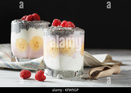 Joghurt mit Chia Samen und Früchte, Bananen und Himbeeren. gesundes Frühstück oder Snack am Morgen Konzept Stockfoto