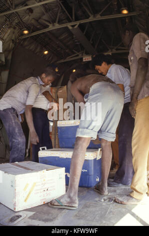 Khartum, Sudan - September 1986 - Ein 1 Million Dollar Dollar Dollar schweres Hilfsprojekt für die Opfer von Hungersnöten in der vom Krieg verwüsteten Südsudan „Operation Rainbow“ ist wegen der Auseinandersetzung mit politischen Überlegungen zwischen der sudanesischen Regierung und den Rebellengebieten mit bürokratischem Aufwand verbunden. Das gecharterte C-130 Hercules-Flugzeug bereitet sich auf die Lieferung von 210 Tonnen Nahrung pro Woche vor, mit zwei Flügen täglich, um Hunger und Mangelernährung zu verhindern. Finanziert wird es von den Vereinten Nationen, den Niederlanden, den Vereinigten Staaten, Kanada, dem Kinderhilfswerk der Vereinten Nationen und dem Welternährungsprogramm. Staffan D. de Mistura (Khaki ja Stockfoto