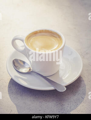 Tasse Espresso Kaffee in der Morgensonne Licht auf den Tisch draußen. Kaffee entspannen, bevor Arbeiten. selektive Fokus Stockfoto