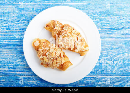 Traditionelles französisches Frühstück Croissant mit Mandeln auf einer Platte Stockfoto