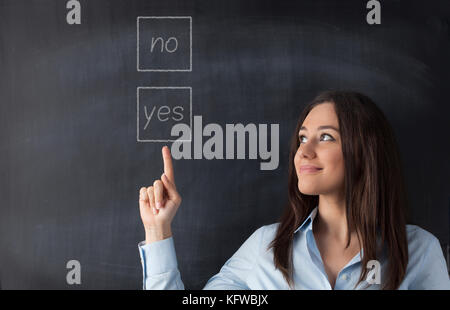 Lächelnd business Frau in ein 'Ja' geschriebenen Text auf der Tafel zu Punkt Stockfoto