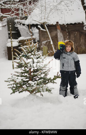 Junge mit Säge sägen Weihnachtsbaum Stockfoto