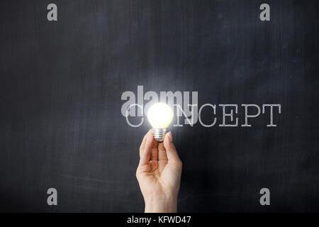 Hand hält eine Glühbirne auf Konzept text Tafel Stockfoto