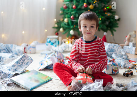 Zwei süße Kinder, junge Brüder, Eröffnung präsentiert am Weihnachtstag, noch im Schlafanzug. Kinder Glück Stockfoto