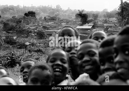 Lächelnd school Jungen mit Slums im Hintergrund, Kampala, Uganda, Ostafrika. Stockfoto