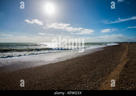 Cooden Beach. Cooden in der Nähe von Bexhill-on-Sea bietet einen schönen Blick auf den Strand in Richtung Pevensey Bay, Beachy Head und Eastbourne. Ein toller Ort, um das tosende Surfen zu hören. Stockfoto