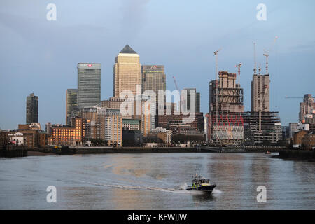 Met Police River Boot auf der Themse in Limehouse mit Canary Wharf im Bacground, während die Sonne über der Hauptstadt untergeht. Stockfoto