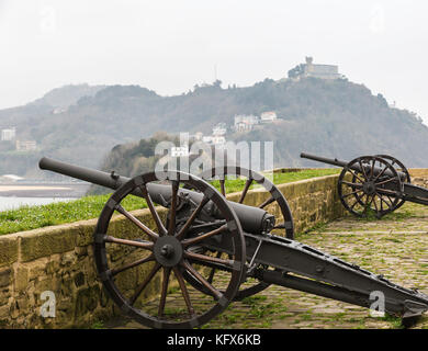 Zwei alte Kanonen auf ein Fort an der Wand in donostia mit Blick auf den Ozean Stockfoto