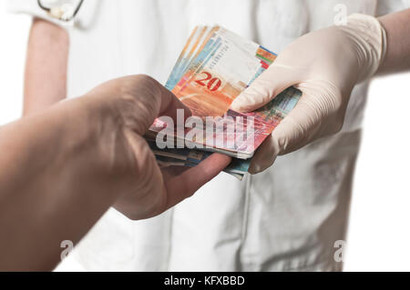 Arzt, die große Menge der Schweizer Banknoten als Bestechung. die Korruption im Gesundheitswesen. Stockfoto