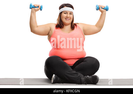 Übergewichtige Frau Trainieren mit kleinen Hanteln auf einer Gymnastikmatte auf weißem Hintergrund Stockfoto