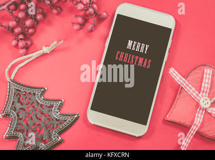 Weihnachten smart phone auf rotem Hintergrund. Stockfoto