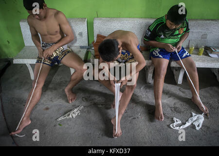 Kinder während des Trainings, Vorbereitung der Verbände, um ihre Hände zu schützen, Muay thai Camp, Bangkok, Thailand Stockfoto