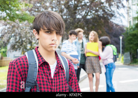 Unglückliche Junge, Tratschten über die Schule Freunde Stockfoto