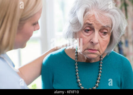 Care worker im Gespräch mit depressiven älteren Frau zu Hause Stockfoto