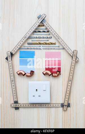 Bauteile in Form von Haus auf Holz- Hintergrund angeordnet Stockfoto