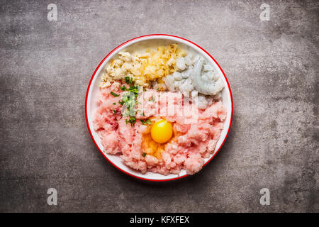 Fisch Pasteten. Kochen Zutaten in der Schüssel: Hackfleisch Fisch, Ei, Krabben, Zwiebeln und Eingeweichten Brot auf grauem Stein, Ansicht von oben Stockfoto