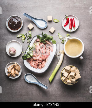 Verschiedene asiatische Zutaten zum Kochen in Schalen für pikante asiatische Suppe mit Tofu und Fleisch: Fleisch in Scheiben geschnitten, Ingwer, Chili, gewürfelte Tofu, austernsauce, Knoblauch Stockfoto