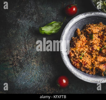 Lecker couscous Salat in der Schüssel auf dunklen rustikalen Hintergrund, Ansicht von oben, in der Nähe der Grenze. gesunde Ernährung, vegetarische oder vegane Ernährung Konzept Stockfoto